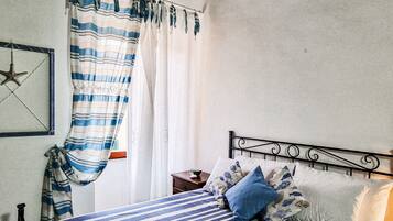 A bedroom with a bed, striped curtains, a star decoration, and a nightstand.