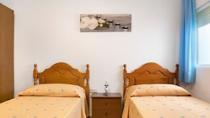 A double bed room with two wooden headboards, a nightstand with a lamp, and a painting on the wall. - Apartment 'Ruz Bajo' for 6 people (Conil)