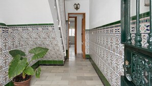 A hallway with patterned tiles, a potted plant, and a door leading to another room. - Apartment 'Ruz Bajo' for 6 people (Conil)