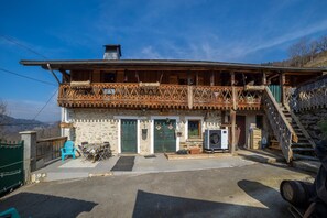 A two-story wooden house with a balcony, a staircase, and a front door. - Apartment 'Anna-Purna' with Mountain View, Shared Terrace and Wi-Fi (Arâches-la-frasse)