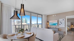 Una habitación de hotel moderna con comedor, sofá y televisor.