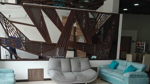 A modern hotel lobby with a grey sofa, a blue sofa, and a reception desk. - HOTEL AMERICAN VISA CORPORATE (Bogotá)