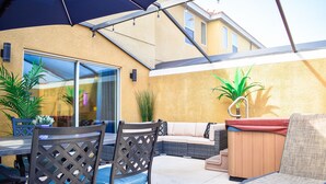 Un patio al aire libre con mesa, sillas, sofá y sillón.