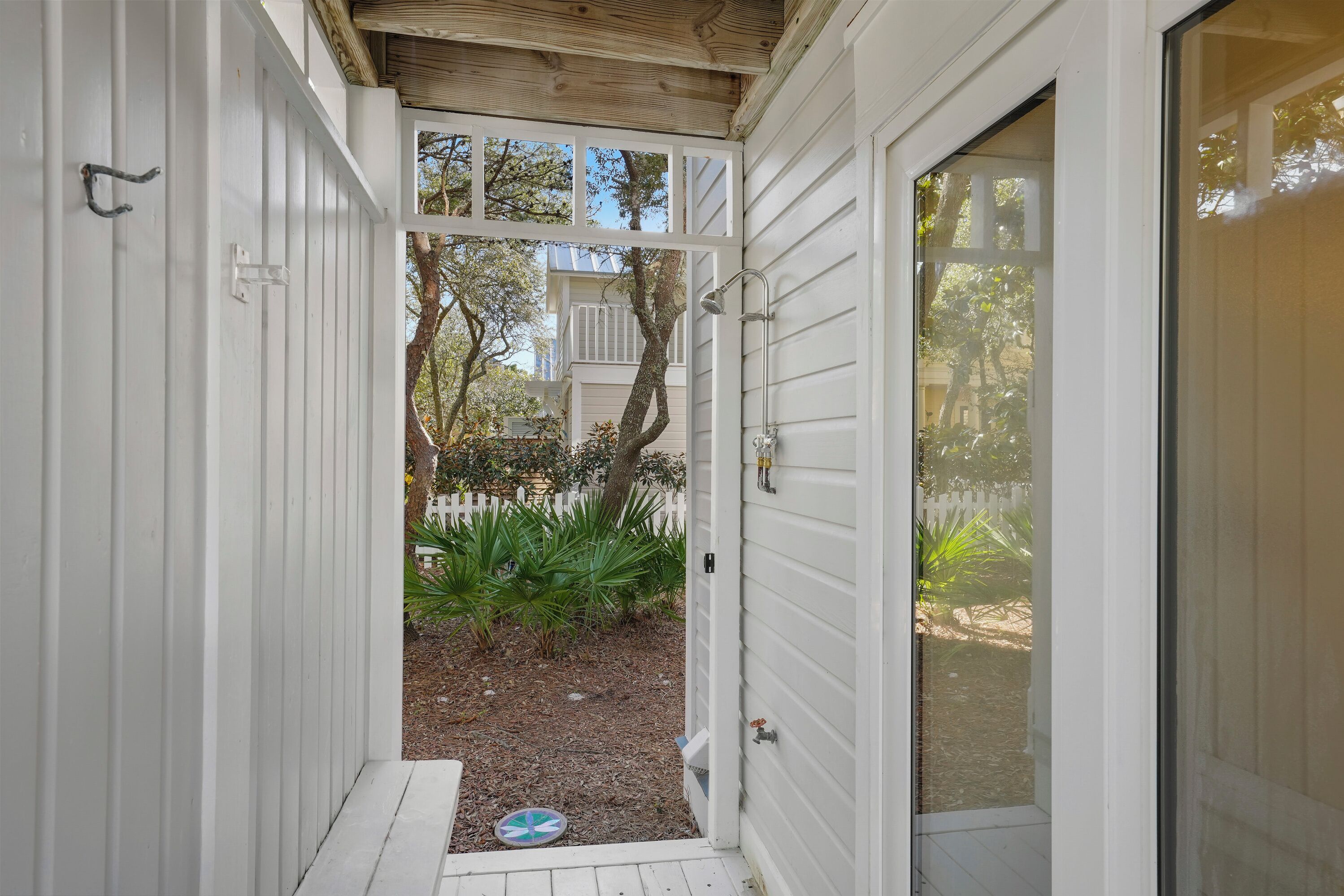 A narrow wooden pathway leading to a white door with a metal handle.