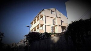 Un edificio de varios pisos con techo plano y un balcón en el segundo nivel.