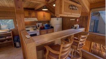Enjoy cooking in this kitchen with a stove, microwave, and refrigerator, and sit at the bar counter with two stools.