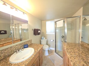 A bathroom with a granite countertop sink, a toilet, a glass shower enclosure, and a large mirror. - Park View Paradise 3 Bedroom Condo by RedAwning (Tahoe City)