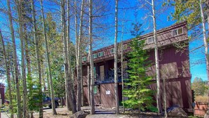A rustic cabin with a balcony, surrounded by tall trees, and a clear sky. - Park View Paradise 3 Bedroom Condo by RedAwning (Tahoe City)