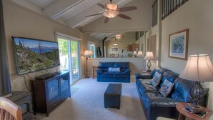 A spacious living room with a fireplace, a large TV, and a ceiling fan. - Park View Paradise 3 Bedroom Condo by RedAwning (Tahoe City)