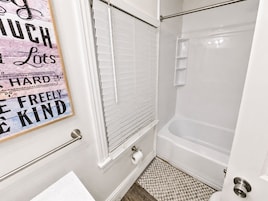 Un baño con ducha, inodoro y perchero para toallas.