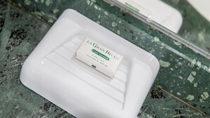 A white rectangular soap dish with a label on a marble surface. - Residence Cervinia 3952 (Valtournenche)