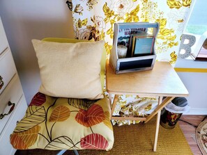 A small room with a bed, a wooden table, a bookshelf, and a patterned wall. - Room-cozy Yellow Queen Bed By Yale U (New Haven)