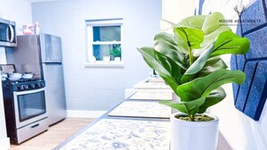 A kitchen with a stove, oven, and microwave. There is a potted plant on a wooden table. - Modern Luxe King Suite Loft + Free Parking & Wifi (Memphis)