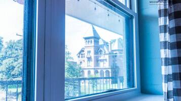 Ein Fenster mit Blick auf ein Gebäude mit einem Turm.