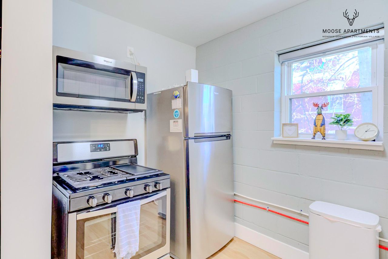 A kitchen with a stove, microwave, and refrigerator.