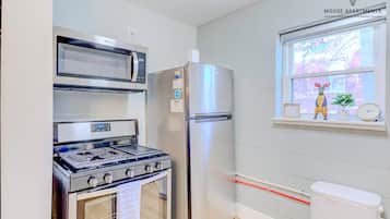 A kitchen with a stove, microwave, and refrigerator.