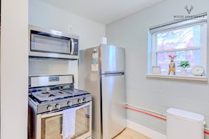 Une cuisine équipée d’une cuisinière, d’un four à micro-ondes et d’un réfrigérateur.