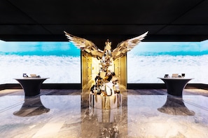 Experience the opulent lobby, featuring a stunning central sculpture and sleek, modern design.