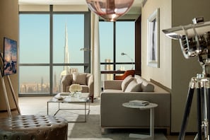 Enjoy a panoramic city view from the large window in this stylish living room, featuring a comfortable sofa, coffee table, and tufted ottoman.