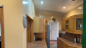 A kitchen with wooden cabinets, a refrigerator, and a clock on the wall. - Repose offer cozy,quite space suitable for business , family, retreats getaways! (Qonce)