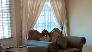 A bedroom with a bed, two armchairs, a wooden ceiling, and a chandelier. - Repose offer cozy,quite space suitable for business , family, retreats getaways! (Qonce)