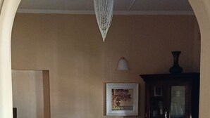 A dining area with a wooden table and chairs, a chandelier, a framed picture on the wall, and a cabinet. - Repose offer cozy,quite space suitable for business , family, retreats getaways! (Qonce)