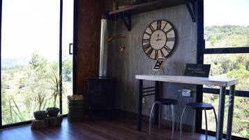 Un interior rústico con un gran reloj de pared, pisos de madera y vistas al exterior.