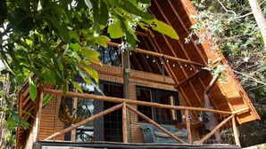 Eine Holzhütte mit Balkon, großen Fenstern und rustikalem Interieur.