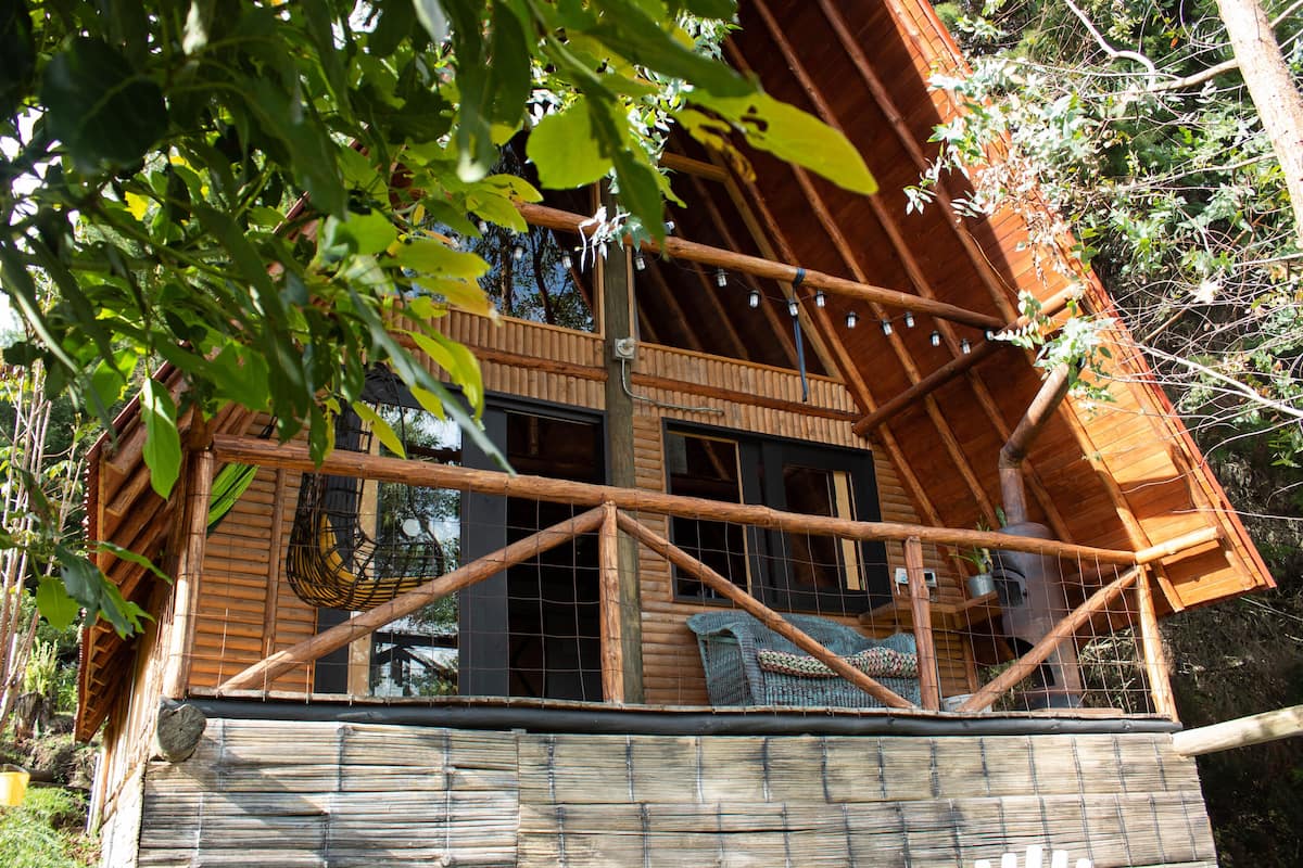 Eine Holzhütte mit Balkon, großen Fenstern und rustikalem Interieur.