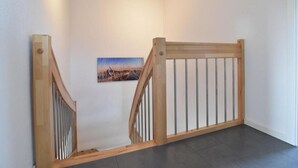 Una escalera con barandas de madera y un cuadro en la pared.