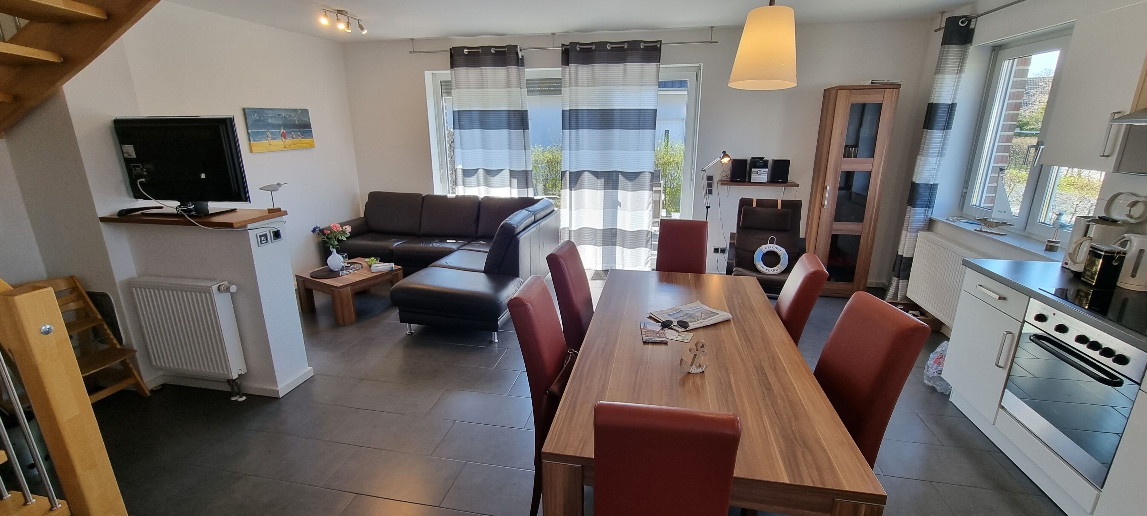 Eine moderne Küche mit Essbereich, einer Couch und einem Fernseher.