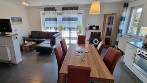 Una cocina moderna con comedor, sofá y televisor.