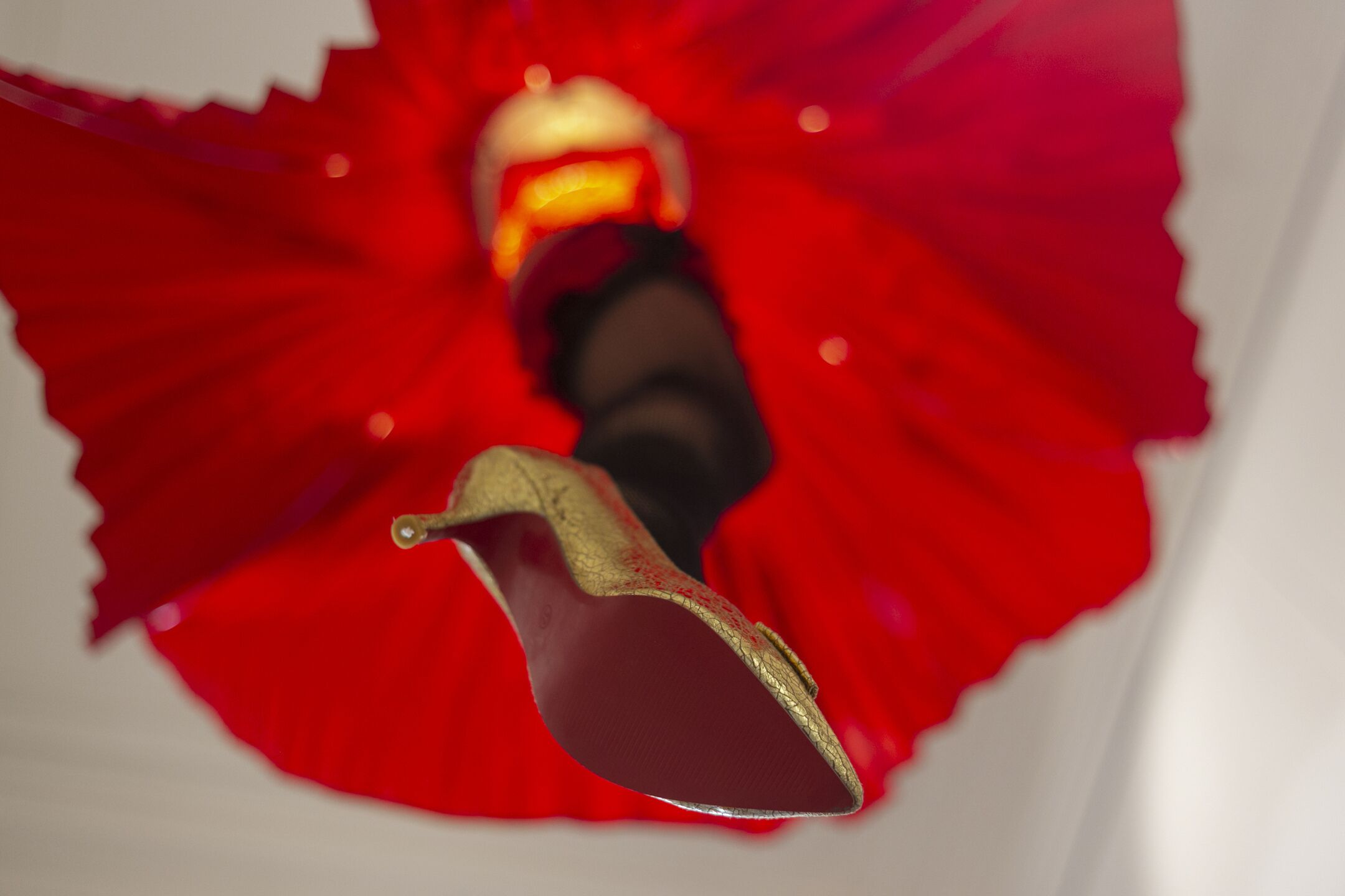 A close-up of a red dress with a gold trim and a black bodice.