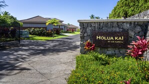 A residential area with a stone wall sign reading "HOLUA KAI AT KE AUHOU" and a gated entrance. - Holua Kai#8  w/ Private Pool, Ocean & Golf Views, Community Pool & Spa (Kailua-Kona)