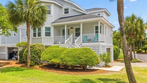 A two-story house with a porch, a garage, and a well-maintained lawn. - Pelican Bay 13 - Brand New Reno! 1 Block to Beach! (Isle of Palms)