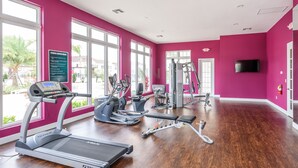 Un gimnasio con cintas de correr, elípticas y equipo de pesas.
