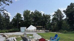 Un espacio al aire libre con carpas, asientos y una parrilla.