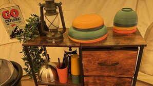 Un ambiente rústico de cocina con una mesa de madera, un farol, un hervidor y un letrero que dice 'GO EXPLORE!'.