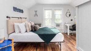 Une chambre à coucher comprenant un lit, une table de chevet et un bureau avec une chaise.