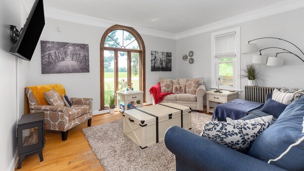 Un salon comprenant un canapé, un fauteuil et une petite table avec une lampe.