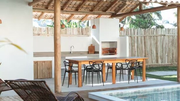 An outdoor patio with a pool, wooden furniture, and a pergola. - Comfortable and charming house 360m from the beach, Porto Seguro. (Porto Seguro)