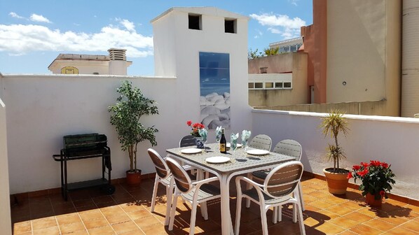 Enjoy al fresco dining on the rooftop with a table for four, a grill, and a beautiful view.