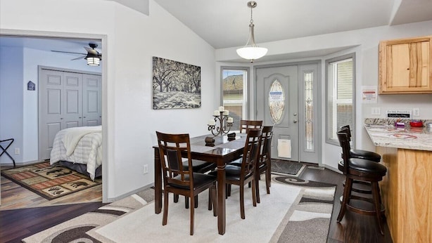 A dining area with a table and chairs, a chandelier, and a painting on the wall.
