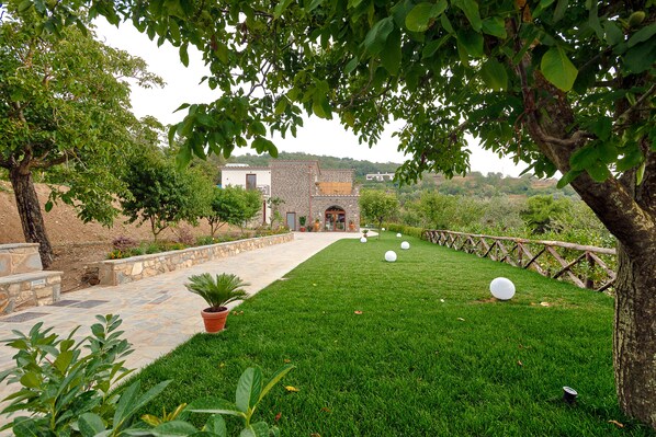 A stone pathway leading to a building with a stone facade and a wooden fence. - Agriturismo La Peppina (Massa Lubrense)