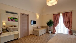 Een moderne slaapkamer met een bed, een bank, een televisie, een spiegel en een potplant.