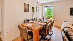 A dining area with a wooden table, leather chairs, and a view of greenery outside. - The Warren - UK42858 (Skirlaugh)