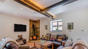 A living room with leather sofas, a fireplace, a television, and a window with a view. - The Warren - UK42858 (Skirlaugh)