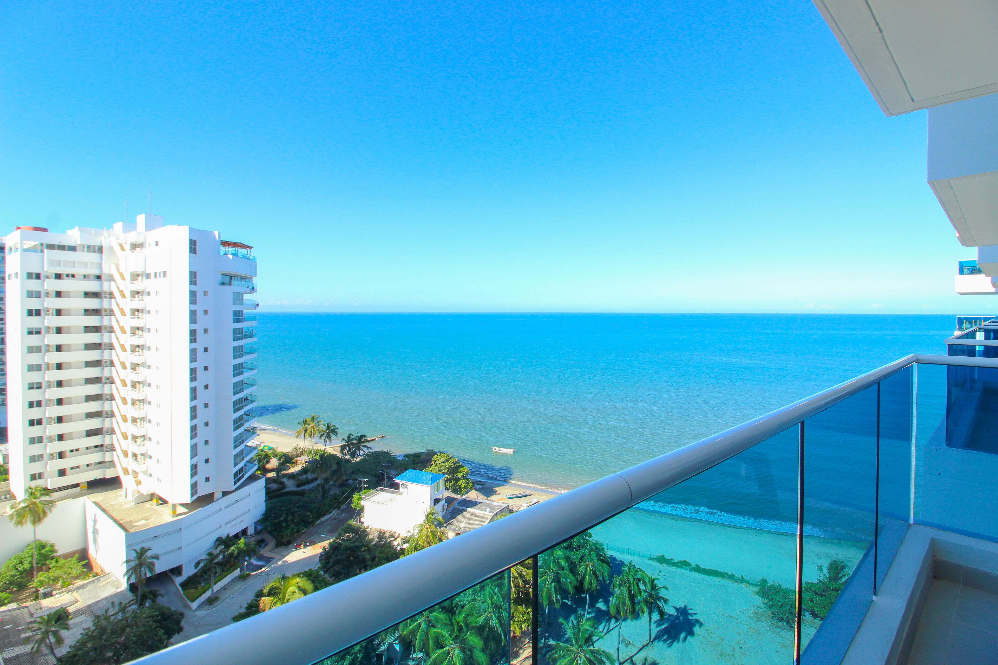 A high-rise hotel with a view of the ocean and beach.