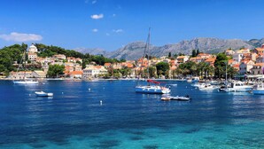 A coastal town with clear blue waters, boats, and a backdrop of mountains and buildings. - Ivana - Two Bedroom Villa, Sleeps 3 (Dubrovnik)