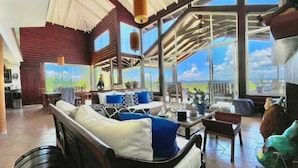 A spacious living area with a large window offering a view of the outdoors. - Fascinante rancho (personal de servicio incluido) (Jarabacoa)